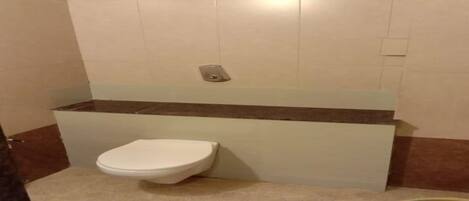 Un baño pequeño con inodoro, lavamanos y cubo de basura.