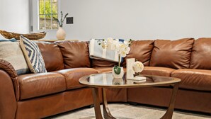 A brown leather sofa with a glass coffee table in a modern living room.