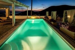 Une piscine avec vue sur les montagnes au crépuscule.