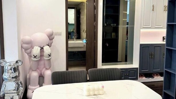 A modern room with a large mirror, a dining table, and a wardrobe with shoe storage. - X-Stay Luxe (Haiphong)