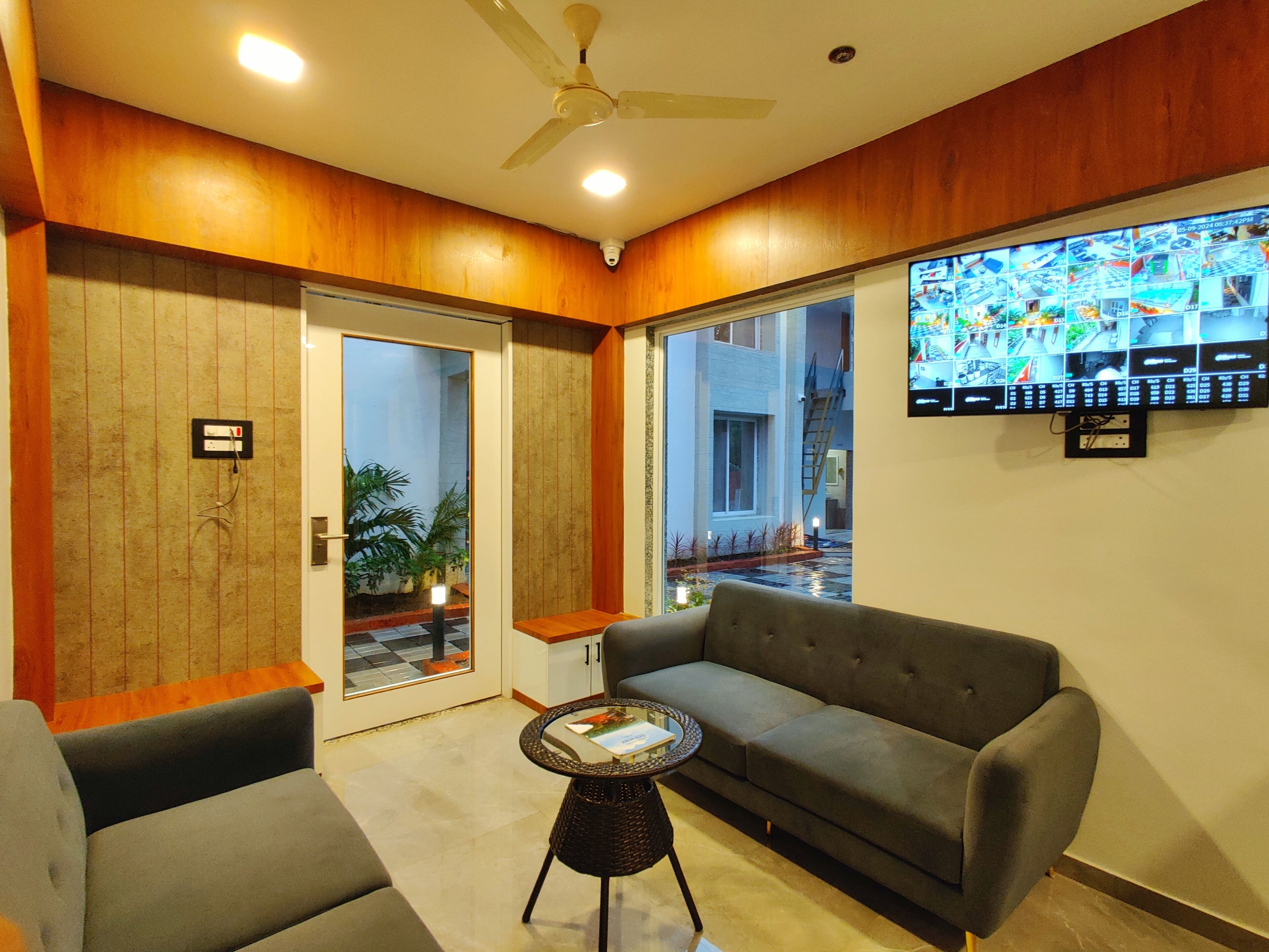 A modern living room with a grey sofa, a small round table, and a ceiling fan.