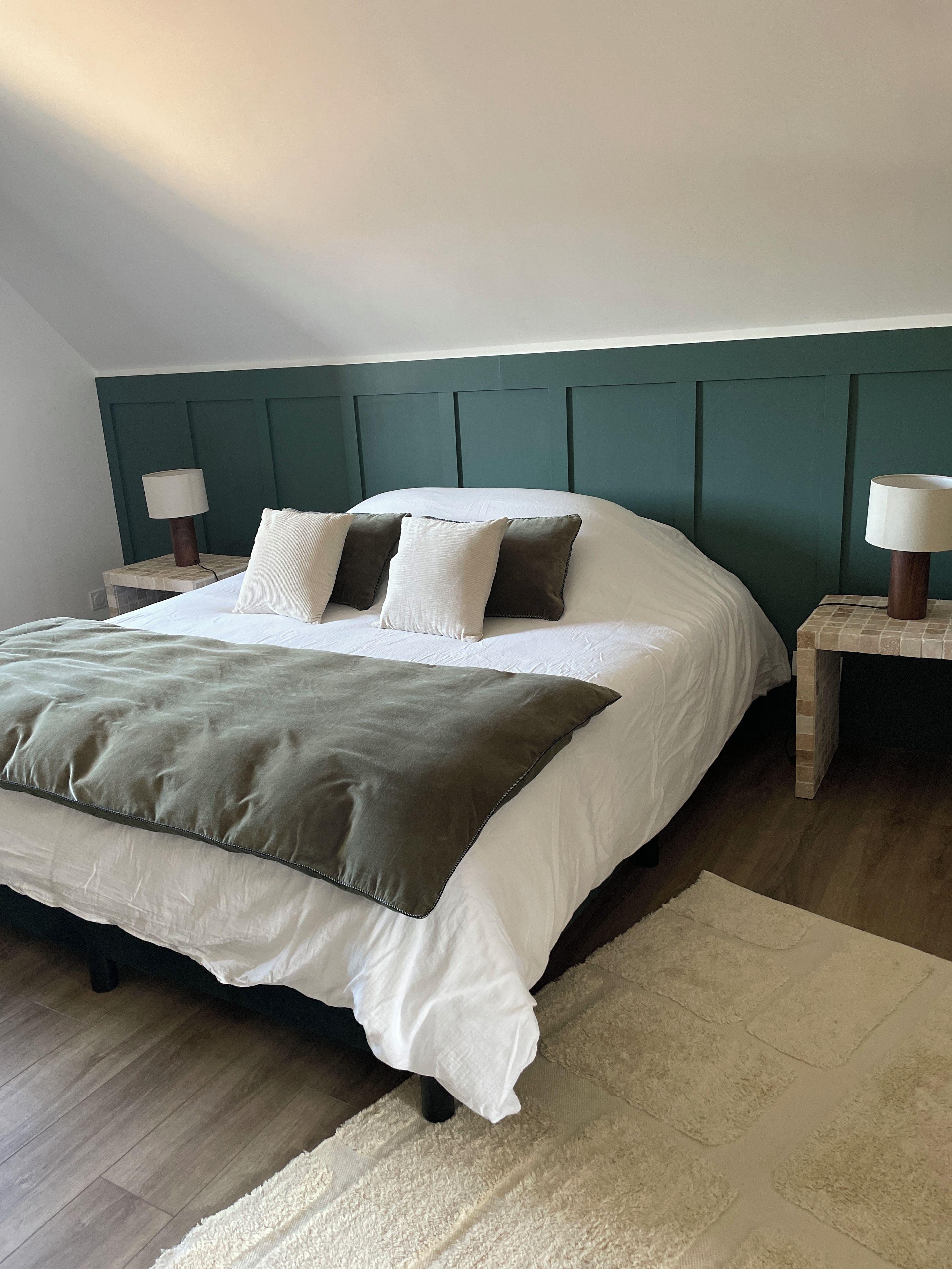 Une chambre à coucher avec un lit, deux tables de chevet et une tête de lit.