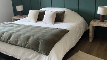 Une chambre à coucher avec un lit, deux tables de chevet et une tête de lit.