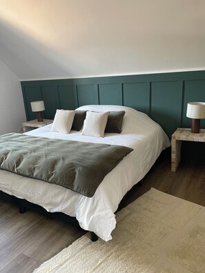 Een slaapkamer met een bed, twee nachtkastjes en een hoofdeinde.