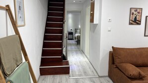 A staircase leading to a bedroom, a green towel on a chair, and a brown sofa. - M B Homes Worker House Lauterstein 8 Wi-Fi (Lauterstein)