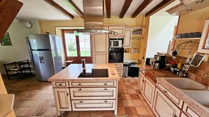 A kitchen with a central island, built-in appliances, and a tiled floor. - Tourangelle House with Indoor Pool, Wifi, Garden (Assay)