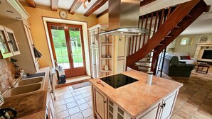 A kitchen with a central island, a built-in oven, and a large window. - Tourangelle House with Indoor Pool, Wifi, Garden (Assay)
