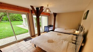 A bedroom with two beds, a large window, and a view of a garden. - Tourangelle House with Indoor Pool, Wifi, Garden (Assay)