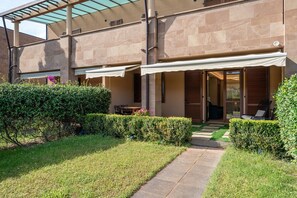 A modern building with a covered patio, a pathway, and neatly trimmed hedges. - Apartment 'Villa Preziosa in Tirrenia' with Private Terrace, Wi-Fi and Air Conditioning (Tirrenia)