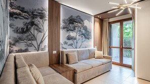 A modern living room with a sectional sofa, a large wall mural, and a contemporary chandelier.
