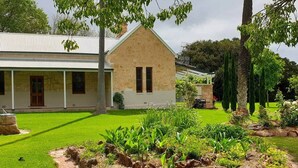A two-story house with a well-maintained lawn and garden.