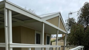 A two-story building with a covered patio area and a small deck. - Poona Farm Estate - The Lodge (Coulta)