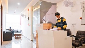 A reception area with a reception desk, a sofa, and a chair. - Hotel Yashobhoomi Inn (New Delhi)