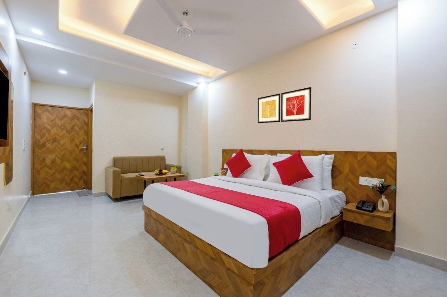 Una habitación de hotel con cama, mesita de noche y sofá.