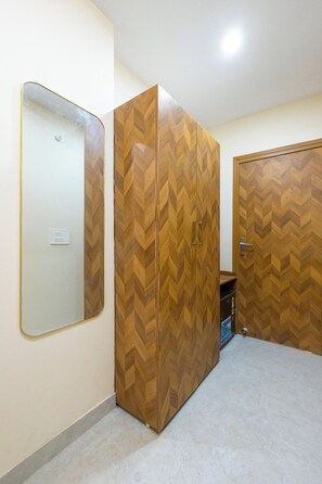 Een kamer met een grote kast, een spiegel en een deur.
