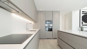 A modern kitchen with a built-in oven, a stainless steel range hood, and a sleek countertop. - Belemia Green Villa, Sintra, Lisbon (São João das Lampas)