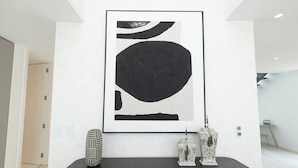 A modern interior with a large abstract painting, a dark console table, and two decorative vases. - Belemia Green Villa, Sintra, Lisbon (São João das Lampas)