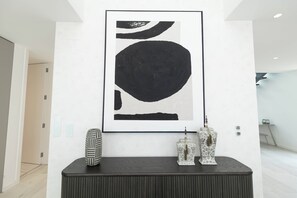 A modern interior with a large abstract painting, a dark console table, and two decorative vases. - Belemia Green Villa, Sintra, Lisbon (São João das Lampas)