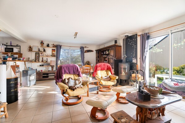 A cozy living room with a fireplace, comfortable seating, and a kitchen area.