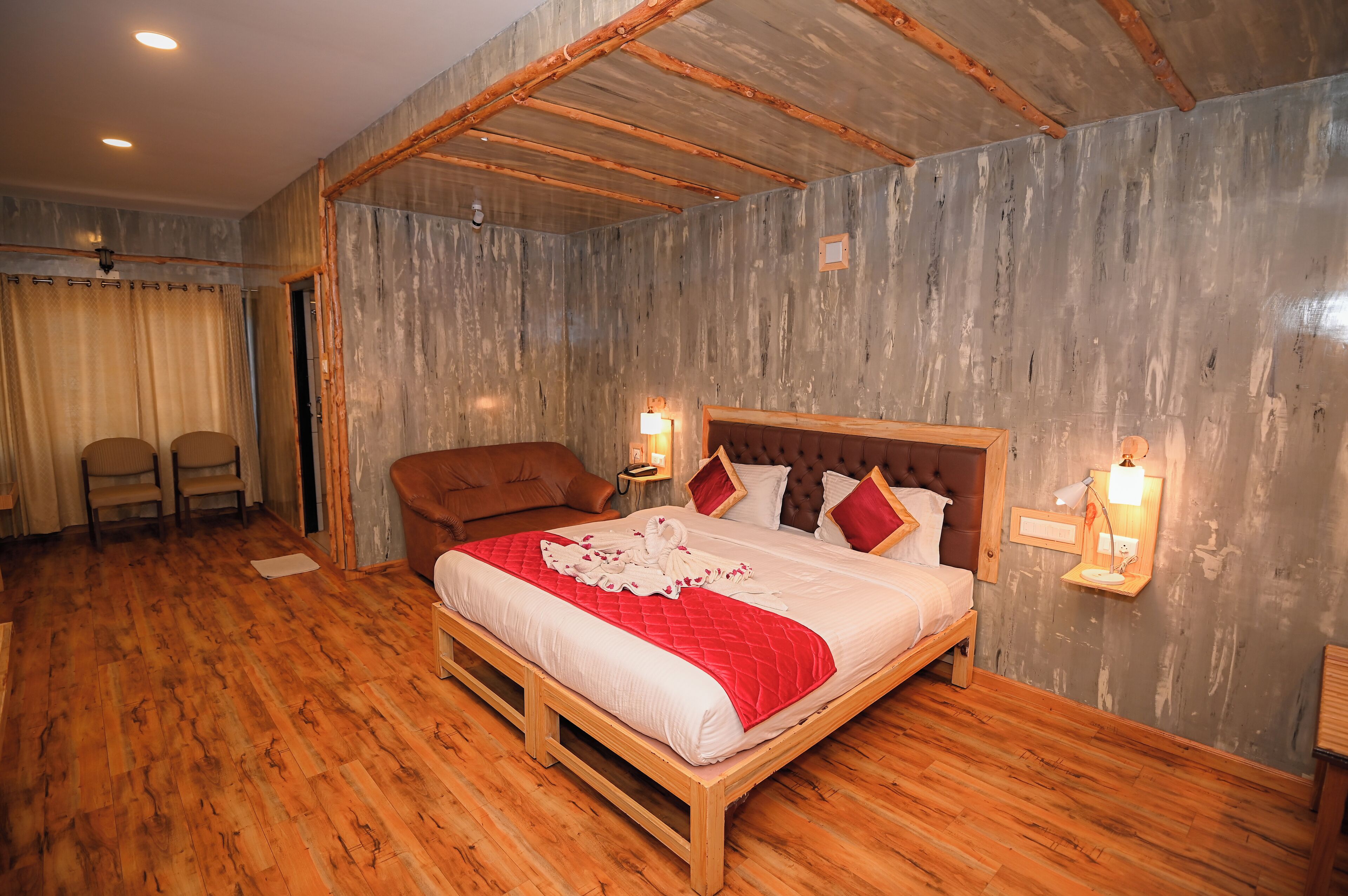 Une chambre à coucher avec un lit en bois, deux lampes de chevet, une tête de lit en bois et une chaise.