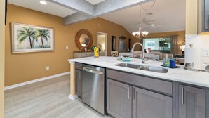 A modern kitchen with a dishwasher, sink, and granite countertop. - HOT TUB & POOL TABLE The Coconut Lounge - Newly Renovated 3/2 in The Village of DeSoto (DeSoto, The Villages)