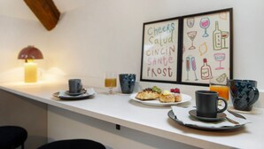 A breakfast setup with a plate of food, a cup, and a glass of orange juice on a white table. - Apartment 'La Scaletta' with Wi-Fi and Air Conditioning (Biella)