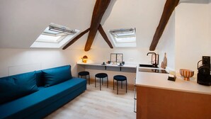 A loft-style room with a sofa, kitchen area, and skylights. - Apartment 'La Scaletta' with Wi-Fi and Air Conditioning (Biella)