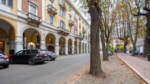 A street lined with multi-story buildings featuring arched doorways and balconies. - Apartment 'La Scaletta' with Wi-Fi and Air Conditioning (Biella)