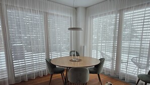 Un comedor con una mesa redonda, cuatro sillas y un perro.