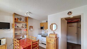 A compact kitchen with a microwave, stove, and wooden cabinets. - Studio 4 pax, south balcony, pets allowed, parking (Les Menuires)