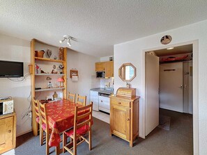 A compact kitchen with a microwave, stove, and wooden cabinets. - Studio 4 pax, south balcony, pets allowed, parking (Les Menuires)