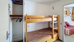 A bunk bed room with a wooden frame, a striped mattress, and a blue plastic cover on the upper bunk. - Studio 4 pax, south balcony, pets allowed, parking (Les Menuires)