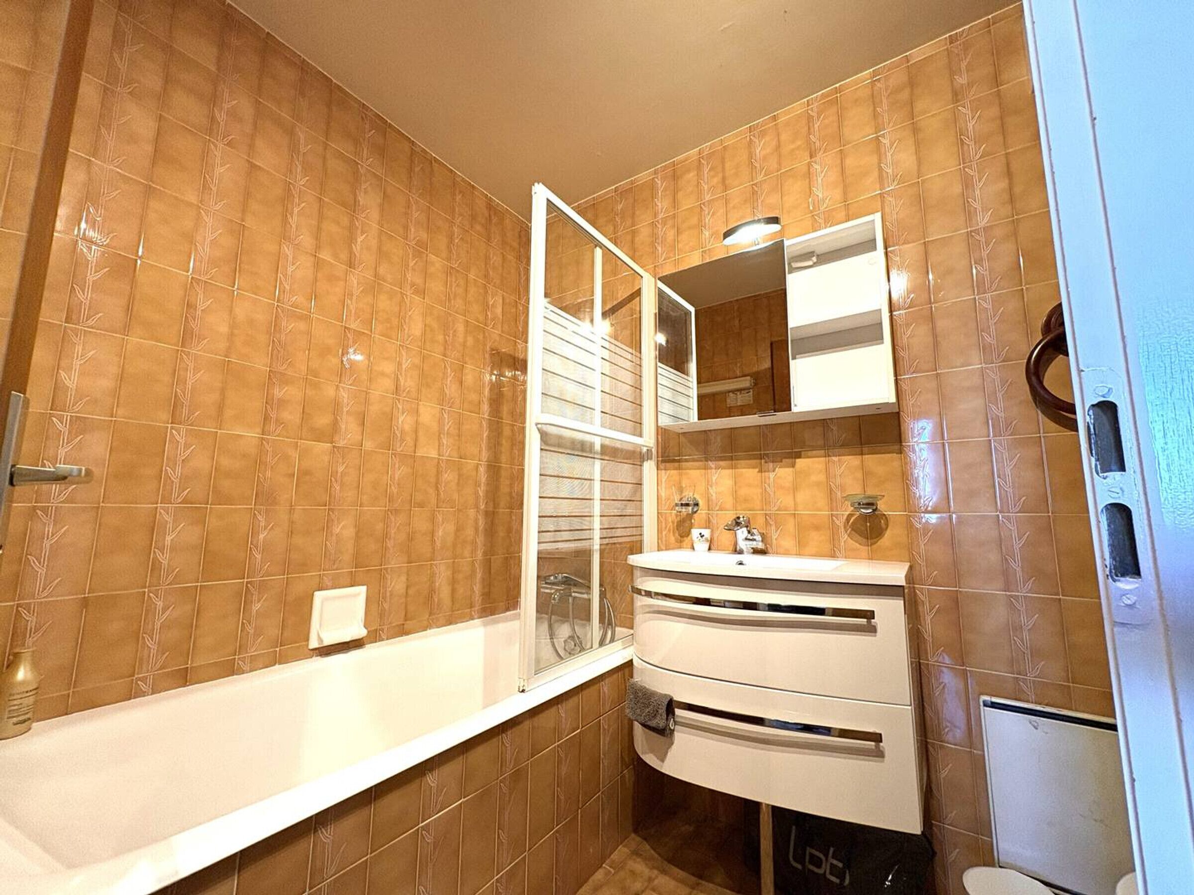 Une salle de bain avec une baignoire, un lavabo, un miroir et des toilettes.