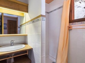 Een badkamer met een houten wastafelmeubel, een wastafel en een spiegel.