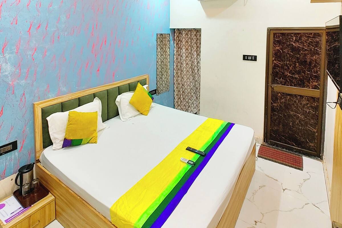 A modern bedroom with a bed, a ceiling fan, and an air conditioning unit.