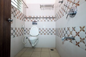 Een aparte badkuip en douche, handdoeken, zeep, shampoo