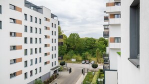 A modern apartment building with multiple floors, balconies, and a parking area. - RentPlanet - Fort Wola (Warsaw)