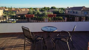 A terrace with two chairs and a table, overlooking a residential area with houses and trees. - El Balcon a Toledo 10 min from puy du fou (Cobisa)