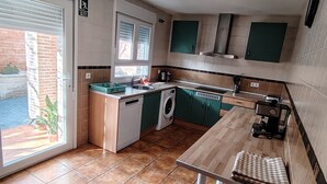 A compact kitchen with a washing machine, a sink, and a window with blinds. - El Balcon a Toledo 10 min from puy du fou (Cobisa)