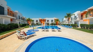 A swimming pool with lounge chairs and a clear blue sky. - Jardins de Pera (Silves)