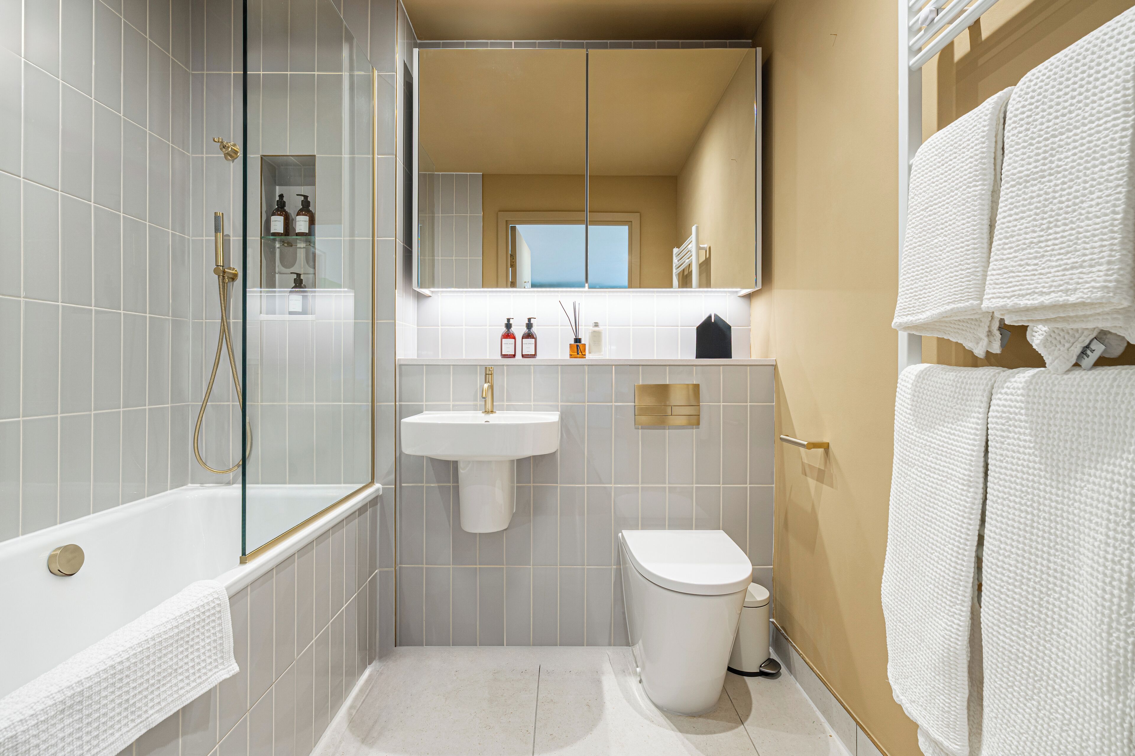 A modern bathroom with a glass-enclosed shower, a white sink, and a toilet.
