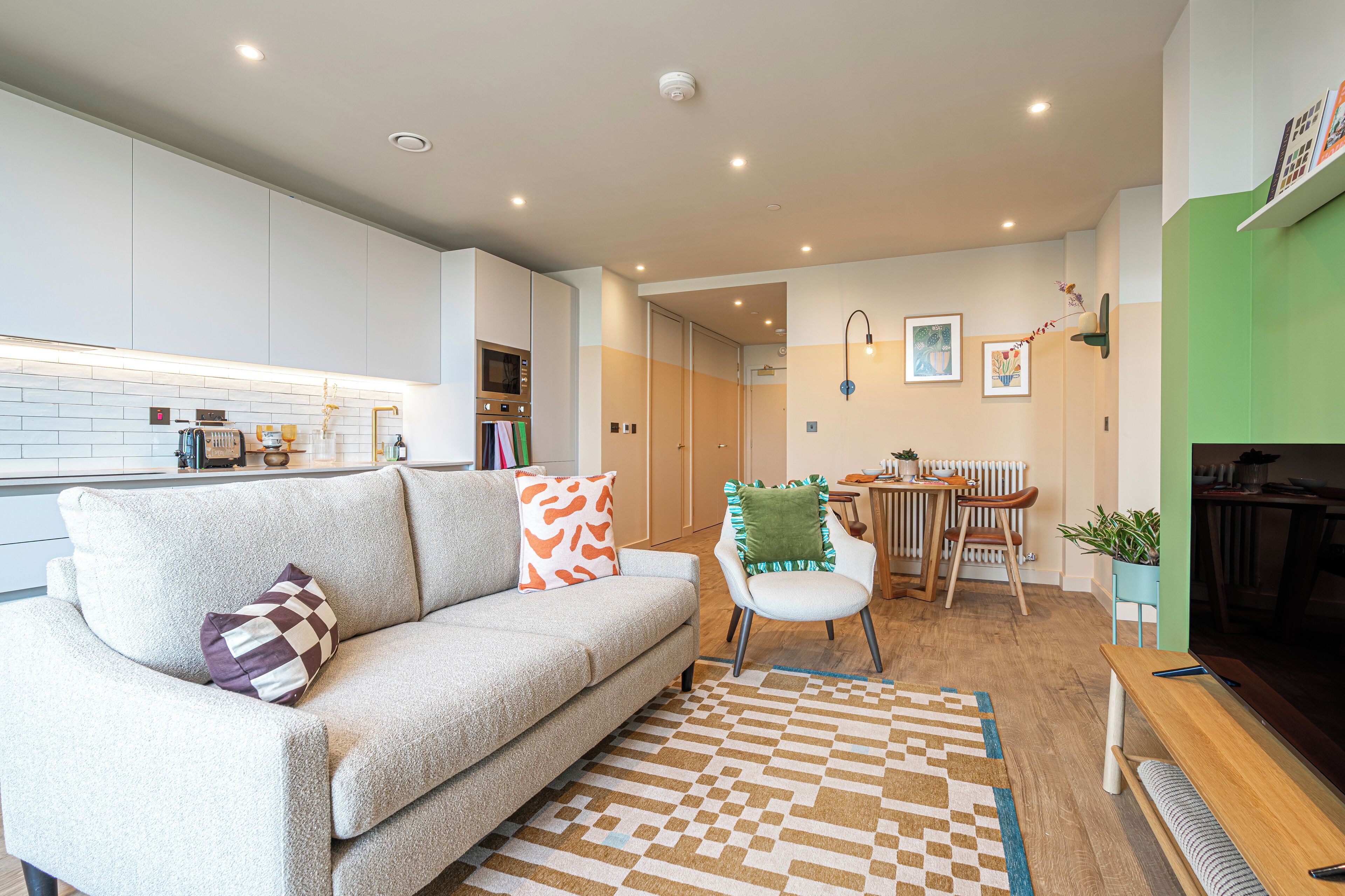 A modern living room with a sofa, a coffee table, and a dining area with a table and chairs.