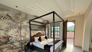 A four-poster bed with a wooden frame and a headboard, a nightstand, and a wall mural. - Nazaara Hills Retreat (Udaipur)