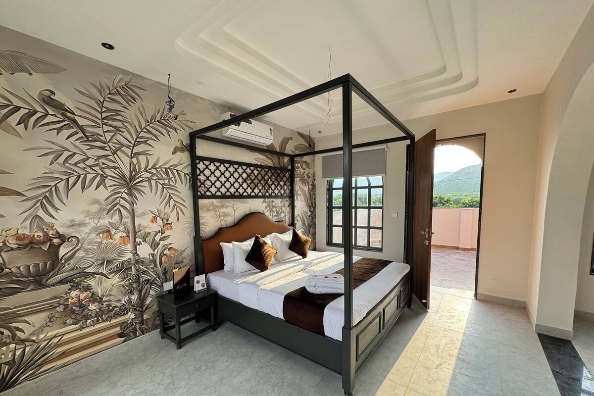 A four-poster bed with a wooden frame and a headboard, a nightstand, and a wall mural.