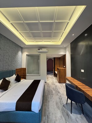 Een moderne hotelkamer met een groot bed, een bureau en een zithoek.