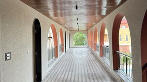 A corridor with patterned flooring, arched doorways, and a tiled ceiling. - Nazaara Hills Retreat (Udaipur)