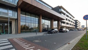 A modern building with a covered entrance, a pedestrian crossing, and a no parking sign. - SPV Apart Pileckiego 258 (Warszawa)