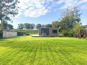 A modern, compact house with a flat roof, a small deck, and a well-maintained lawn. - Vacation home LieblingsKOOG in Friedrichskoog (Friedrichskoog)