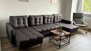 A modern living room with a sectional sofa, a wooden coffee table, and a chair.