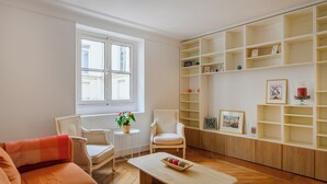 A living room with a sofa, two armchairs, a coffee table, and a bookshelf. - Paris Center Rivoli residence (Paris)
